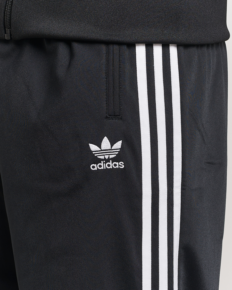 Black adidas pants with white stripes online